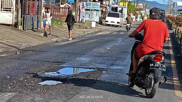 Jalan Ahmad Yani, Kelurahan Batang Beruh, Kecamatan Sidikalang, Kabupaten Dairi terlihat rusak parah dan berlubang.