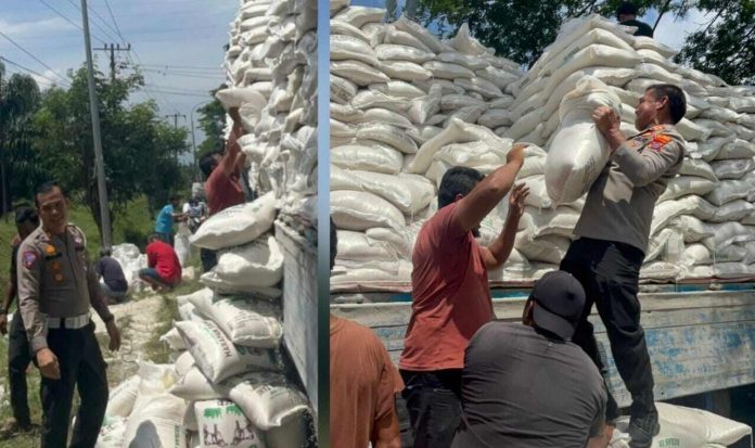 Kapolres Batu Bara AKBP Jose DC Fernandes dan Kasat Lantas AKP Hotlan W Siahaan ikut membantu menaikkan kembali karung beras yang tumpah ke jalan.