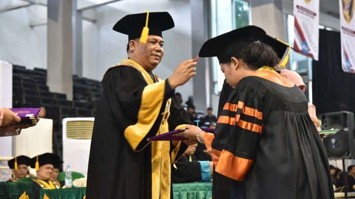 Rektor Unimed Prof Syamsul Gultom saat mewisuda salah seorang mahasiswa.