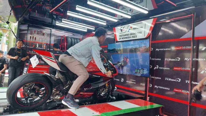 Salah seorang anak muda yang sedang merasakan experience sirkuit mandalika melalui simulator Pertamax Turbo The Ultimate Box MotoGP.