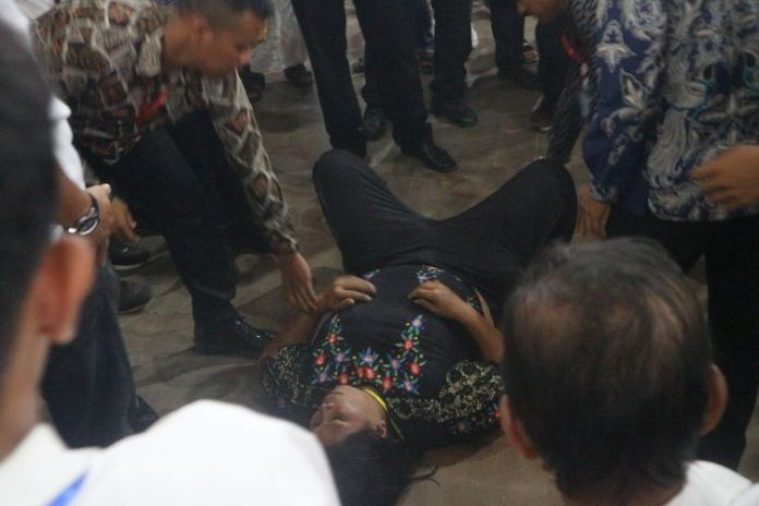 Pasukan pengamanan saat mengamankan wanita yang siram air mineral dan sandal ke arah Presiden Jokowi (f:KOMPAS.com/Rahmat Utomo/mistar)