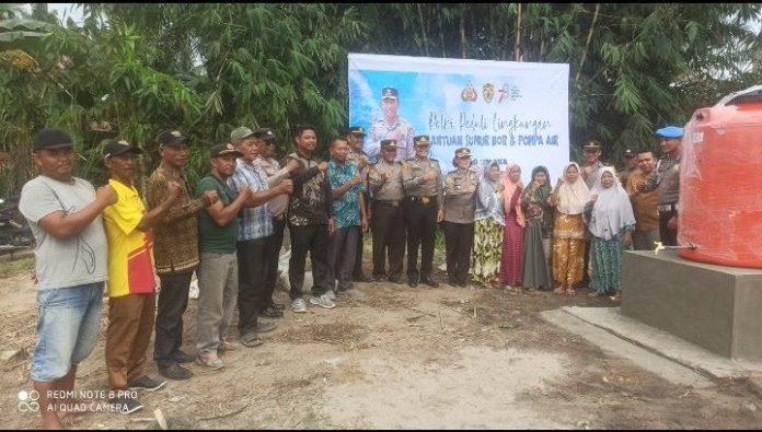 Pejabat Polres Batu Bara foto bersama dengan warga usai peresmian sumur bor