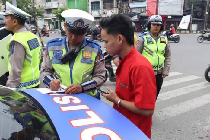 Personel Kepolisian saat memberi teguran kepada pengendara yang melanggar peraturan di Medan.