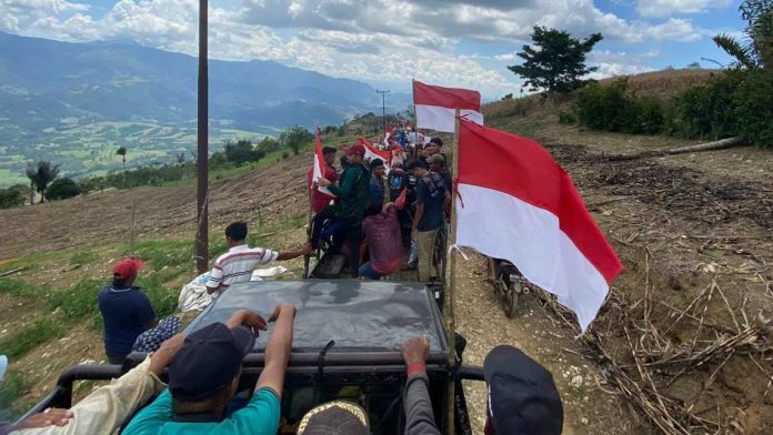 Relawan Jokowi diarak massa warga tiga desa menggunakan mobil bak terbuka.