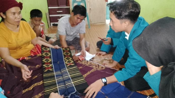 Tim mahasiswa Unimed, melakukan praktik langsung penggunaan aplikasi kepada pengrajin ulos di Samosir