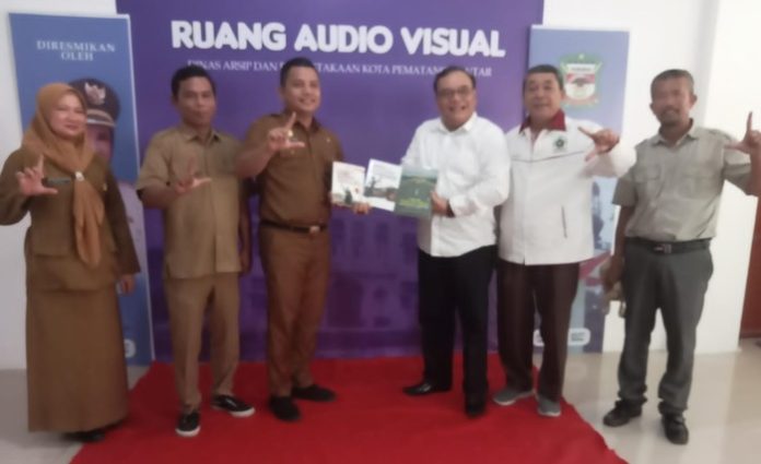 Dr Sarbudin saat menyerahkan buku sumbangannya kepada Kepala Disarpus Kota Pematang Siantar (f:ferry/mistar)