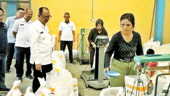 Wakil Bupati Simalungun Zonny Waldi mengecek proses penimbangan beras yang nantinya akan dibagikan ke masyarakat (f:hamzah/mistar)