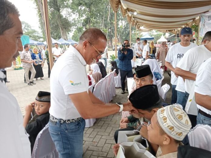 Direktur Irwan Perangin-angin menyalami anak yatim usai memberikan bingkisan di Halaman Mesjid Ubudiyah Aulawiyah Tanjung Morawa (f:ist/mistar)