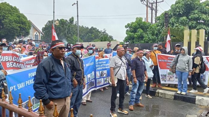 Karyawan membawa spanduk saat unjuk rasa di Polda Sumut untuk meminta perlindungan (f:ist/mistar)
