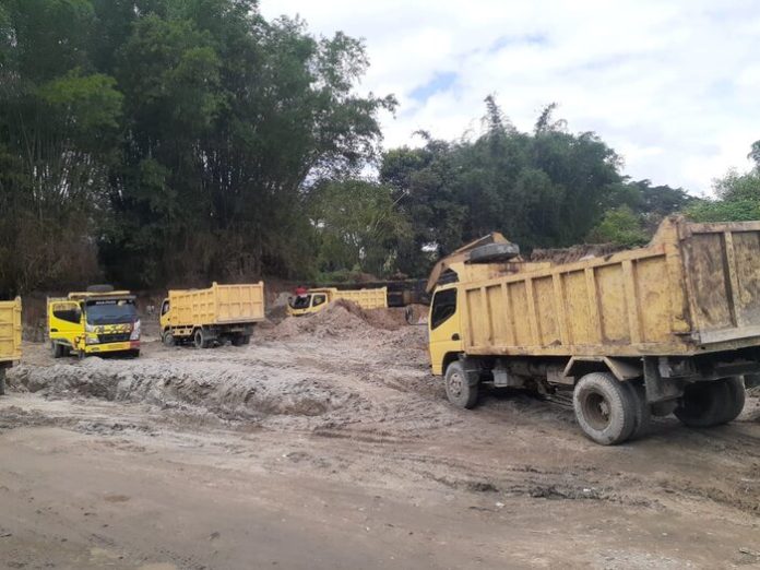 Truck Colt Diesel antri menunggu muatan tanah urug di Desa Parparean I, Kecamatan Porsea (f:ist/mistar)