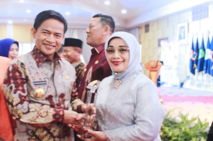 Pj.Gubernur Sumatera Utara Hassanudin menyerahkan penghargaan kepada wakil Bupati Labuhanbatu Hj Ellya Rosa Siregar (f:ist/mistar)