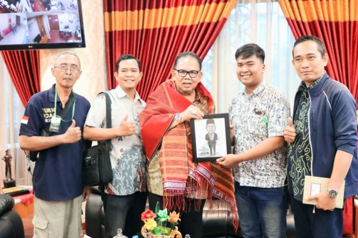 Ketua DPRD Sumatera Utara, Baskami Ginting mendapat penghargaan berupa ulos dari panitia perayaan Natal Driver Online dan Pedagang Kaki Lima Medan. (f:dedy hutajulu/mistar)