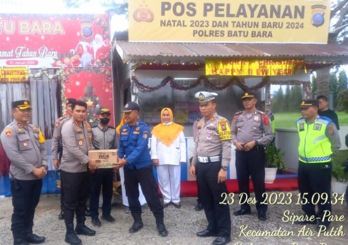 Kapolres Batubara AKBP Taufiq Hidayat Thayeb memberikan paket Natal kepada personil Pospam dan Posyan (f:ist/mistar)