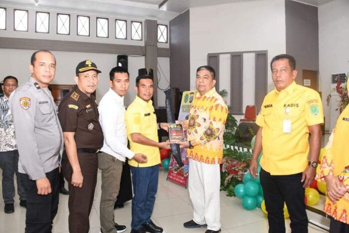 Wabup Labura H Samsul Tanjung menyerahkan buku stop pungli kepada Kepala Bappeda HM Ikhwan Lubis pada sosialisasi Stop Pungli di aula Ahmad Dewi Syukur (f:ist/mistar)