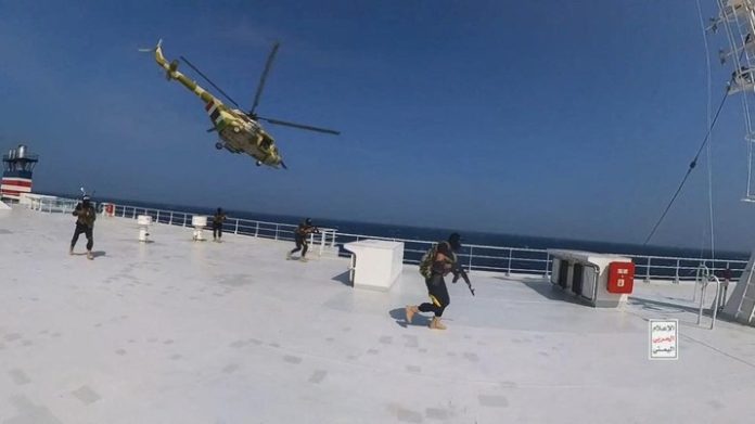 Helikopter militer Houthi melayang di atas kapal kargo Galaxy Leader saat pejuang Houthi berjalan di dek kapal di Laut Merah dalam foto yang dirilis 20 November 2023 (f:reuters/mistar)