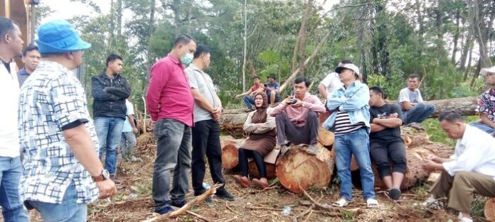 Sekelompok orang di Jalan Sadar Siborongborong menghalangi pengusaha kayu yang memiliki SHM dan di lokasi terlihat Kapolsek Siborongborong AKP P Purba (f:ist/mistar)