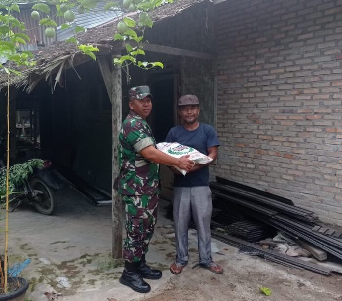 Serka Jazim menyerahkan bantuan beras kepada salah seorang warga kurang mampu di Desa Medan Krio Sunggal (f:ist/mistar)