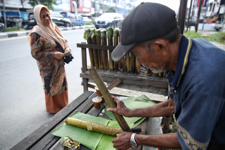 Pedagang lemang pisahkan bambu dari lemang