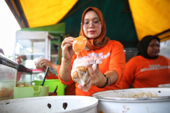 Penjual sedang menyiapkan satu porsi toge panyabungan di Medan