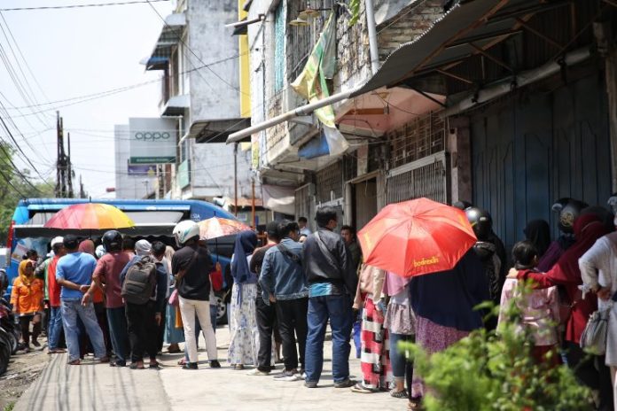 Warga Kota Medan mengantri untuk dapat menukarkan uang baru di mobil pelayanan keliling