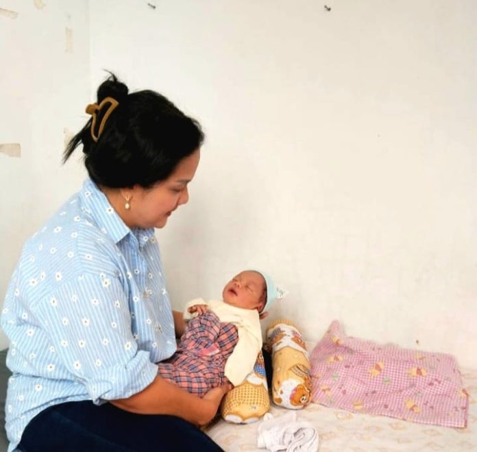 Kapus Sarimatondang, Kristin Nahampun saat menggendong bayi yang ditemukan di belakang Musholla di Kecamatan Sidamanik, Simalungun.(f:ist/mistar)