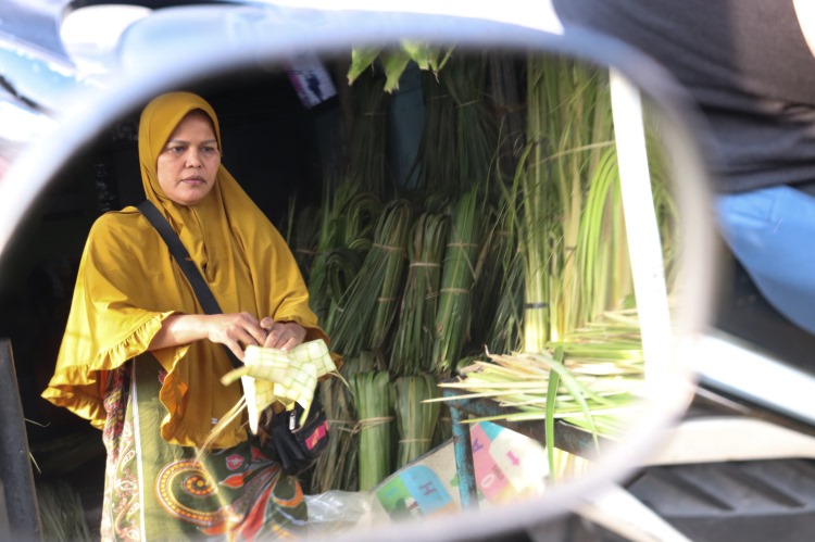 Fitri menuju tempat pemajangan sarang ketupat