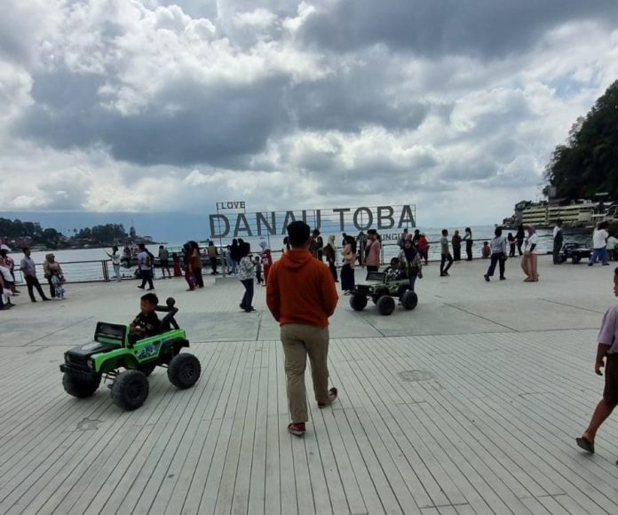 Para pengunjung menikmati panorama Danau Toba di Ruang Terbuka Publik (RTP) Parapat, Kecamatan Girsang Sipangan Bolon, Simalungun