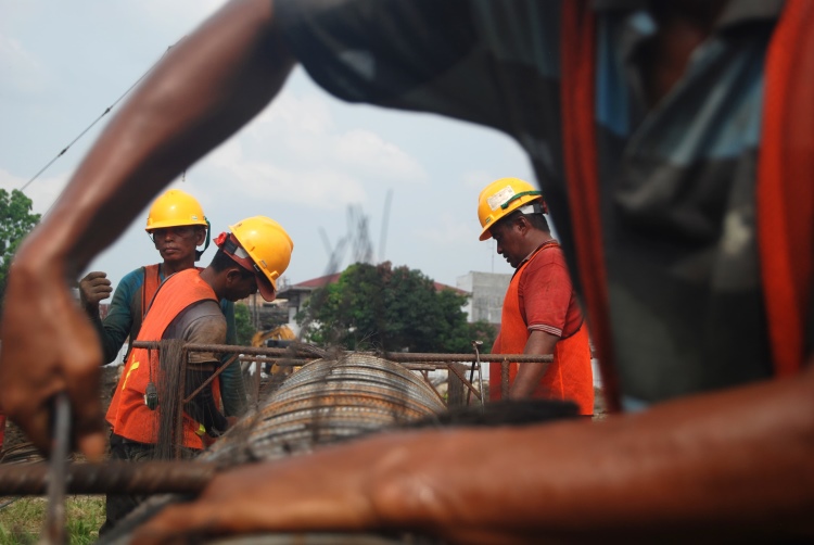 Pekerja konstruksi sedang merangkai besi ulir dalam pembangunan stadion Teladan Medan