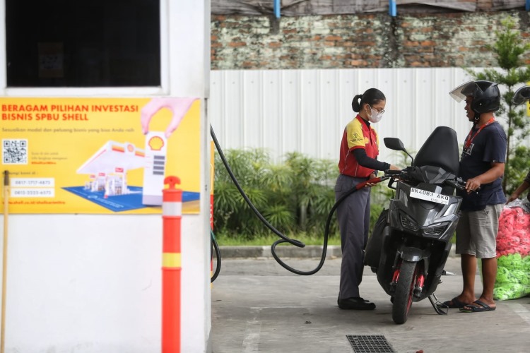 Petugas SPBU milik Shell mengisi BBM pelanggan kendaraan roda 2 di Medan