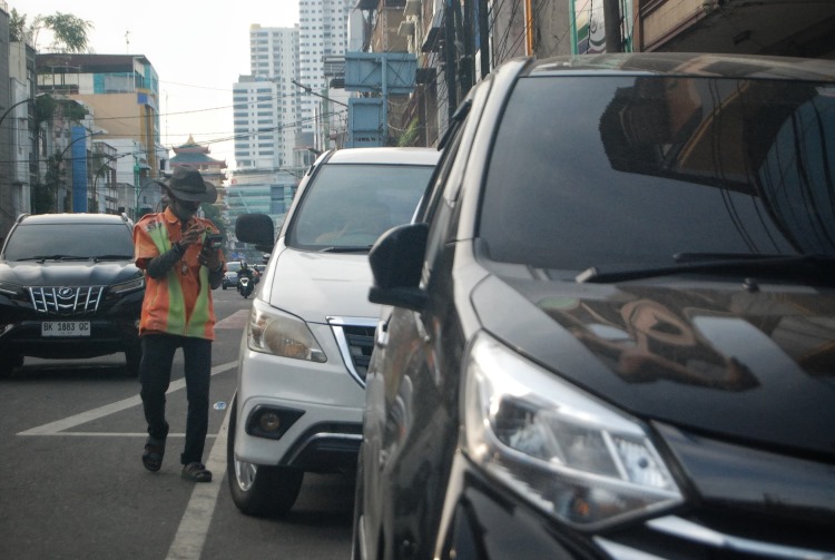 Petugas parkir di Medan sedang melayani masyarakat yang akan membayar dengan sistem E-Parking