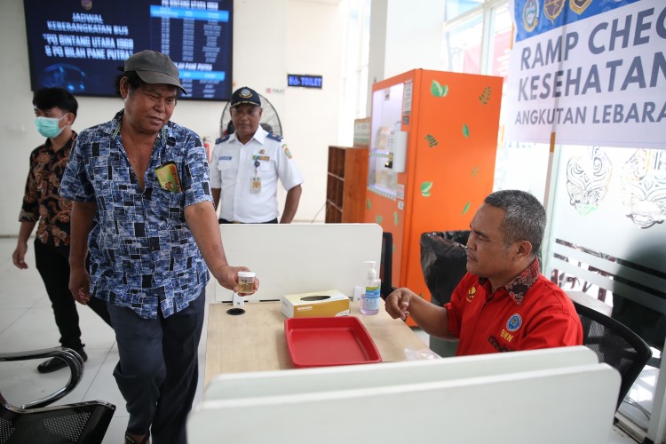 Salah seorang sopir bus AKAP menyerahkan botol berisi urine untuk diperiksa oleh petugas BNNP Sumut di Terminal Amplas Medan