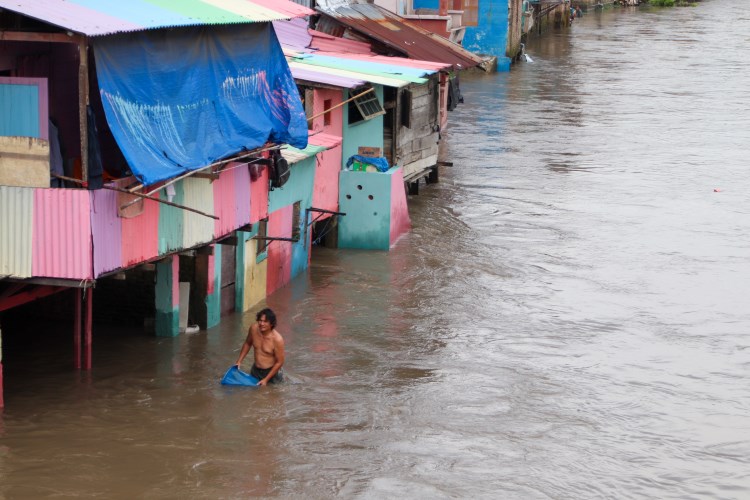 Warga Kampung Aur menguras air sungai yang masuk ke rumahnya