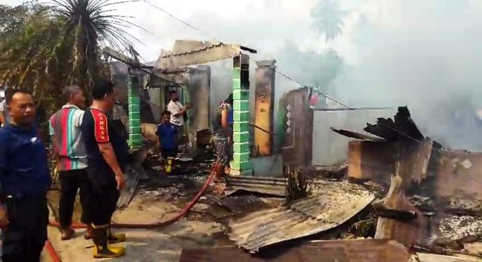 Petugas memadamkan api yang membakar empat unit rumah di Sinaksan, Kabupaten Simalungun (f:ist/mistar)