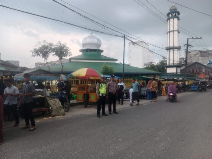 Anggota Polres Tanjungbalai menjaga masjid (f:ist/mistar)