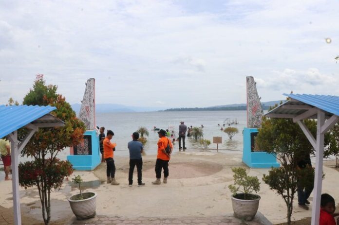 Tampak petugas BPBD Toba siaga mengawasi para pengunjung yang asyik mandi di Pantai Pasir Putih Parparean. (f.ist/mistar)