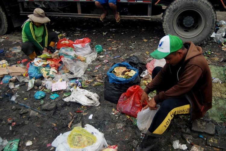 Dua orang pemulung sedang memilah sampah di Medan