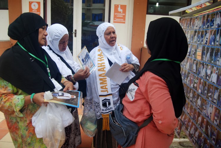 Jamaah calon haji melihat foto yang dicetak di Asrama Haji Medan