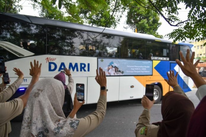 Keluarga melambaikan tangan kepada jamaah calon haji saat pemberangkatan di Asrama Haji Embarkasi Kota Medan, Sumatera Utara
