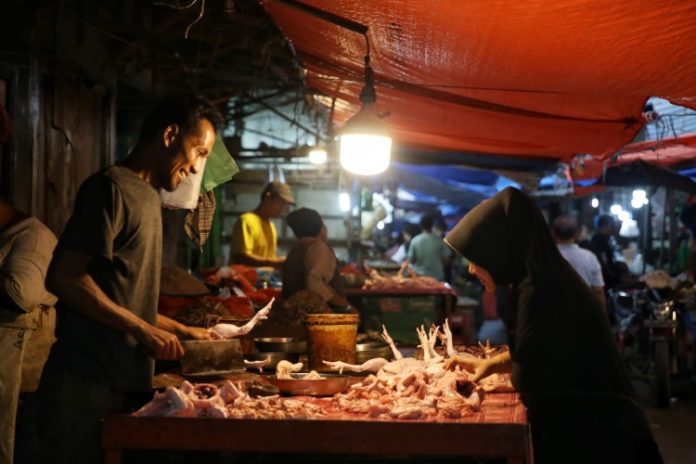 Pedagang ayam potong sedang melayani pembeli di Pasar Sei Sikambing Medan