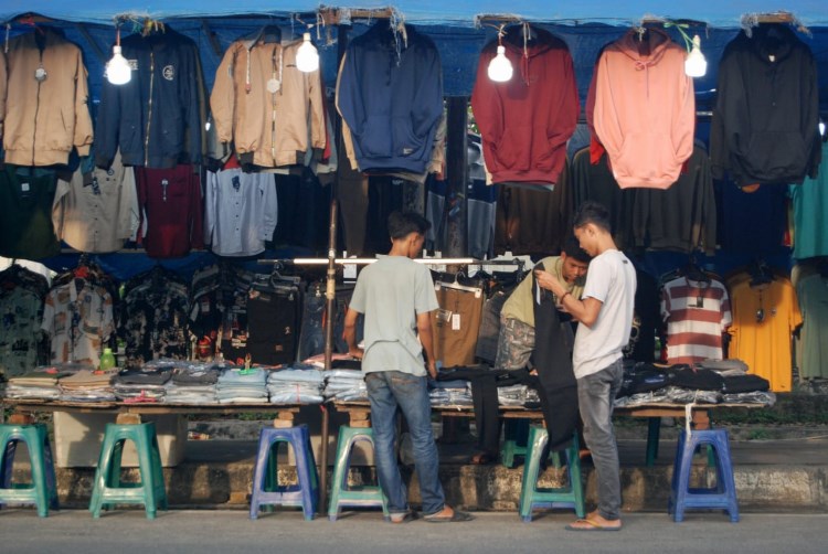 Pedagang pakaian di Medan sedang melayani pembeli