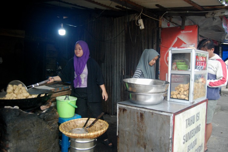 Pedagang tahu sumedang di Medan sedang melayani pembeli