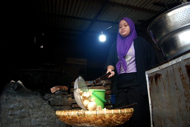 Pedagang tahu sumedang di Medan sedang mengangkat tahu yang selesai digoreng