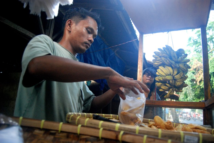 Penjual pisang goreng tanduk crispy sedang membungkus pesanan pembeli di Medan