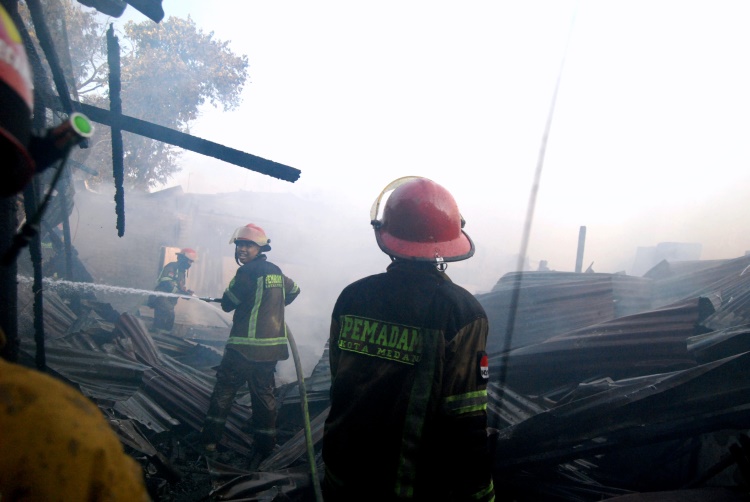 Petugas pemadam kebakaran Kota Medan menyemprotkan air untuk memadamkan api di Jalan Brigjen Katamso Medan