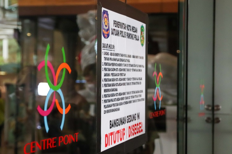 Selebaran dasar hukum penyegelan Mall Centre Point Kota Medan di dinding kaca pintu masuk