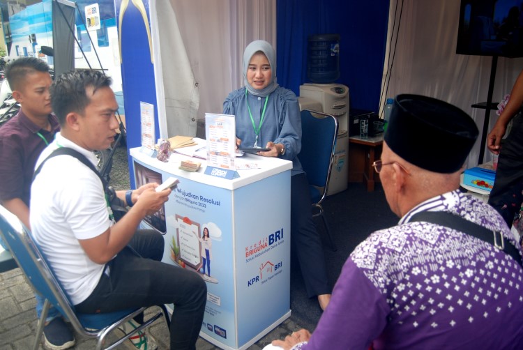 Seorang karyawan BRI sedang melayani Jamaah calon haji di gerai penukaran uang milik BRI di Asrama Haji Medan