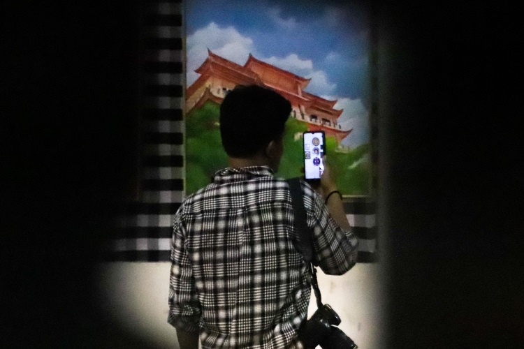 Seorang pengunjung tengah menyalin barcode terkait sebuah lukisan yang dipajang di Urban Culture Exhibition dan Angsa Neduh
