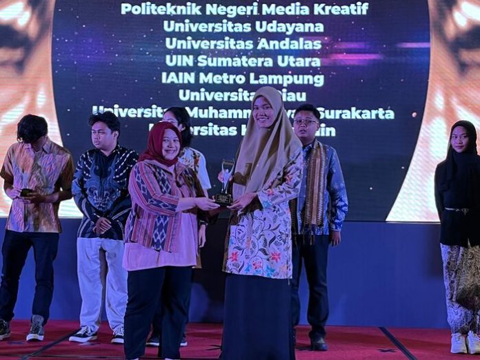 Pimum LPM Dinamika UIN SU, Siti Asyaroh, saat menerima piagam penghargaan dari SPS. (f:ist/mistar)