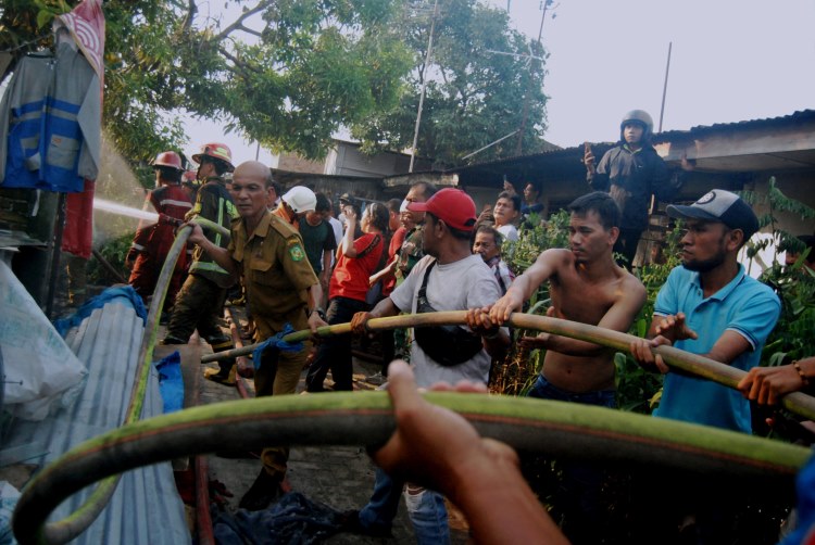 Warga bersama petugas saling membantu menarik selang milik Damkar dalam peristiwa kebakaran di Brigjen Katamso, Kota Medan