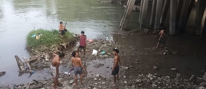 Warga menangkap ikan mabuk di kawasan jembatan Sri Padang tepatnya di belakang PT. Batang Hari, Kota Tebing Tinggi. (f:ist/mistar)